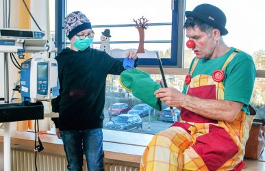 Clown Dodo mit Patient im Krankenhaus-Zimmer mit medizinischem Gerät
